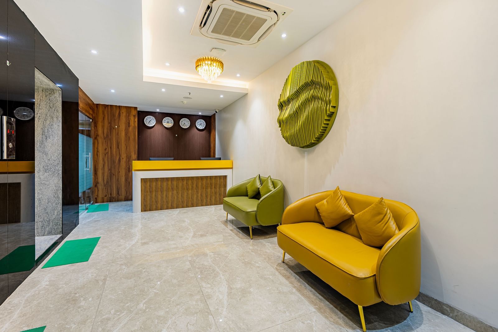 Lemonridge Hotels, KPHB | Lobby with green and yellow seating, contemporary wall decor, and a glimpse of the elevator.